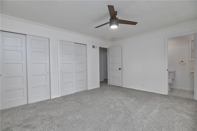 7824 Terrace St, Kansas City, MO 64114 - unfurnished bedroom featuring carpet, crown molding, two closets, ensuite bath, and ceiling fan