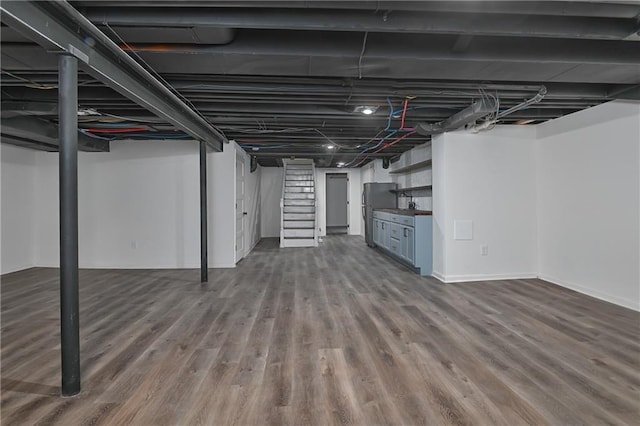 7824 Terrace St, Kansas City, MO 64114 - finished basement with wood finished floors, freestanding refrigerator, and stairway