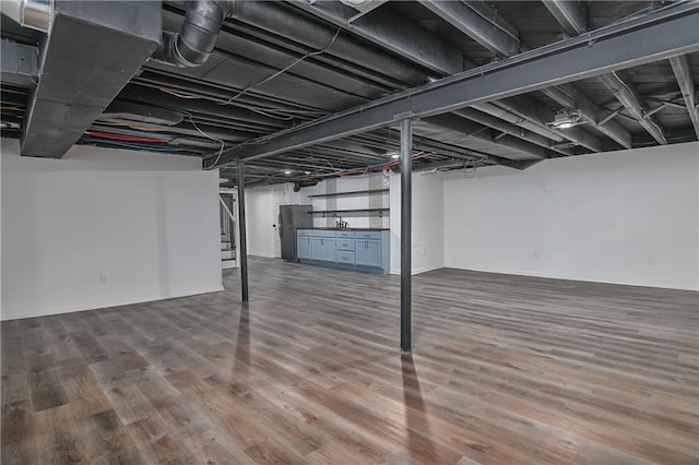 7824 Terrace St, Kansas City, MO 64114 - finished basement featuring wood finished floors, stairway, and freestanding refrigerator