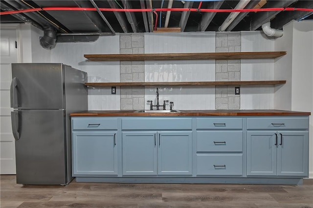 7824 Terrace St, Kansas City, MO 64114 - kitchen featuring freestanding refrigerator, open shelves, butcher block countertops, and wood finished floors