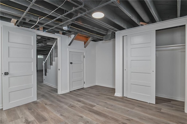 7824 Terrace St, Kansas City, MO 64114 - finished basement with light wood-type flooring and stairway