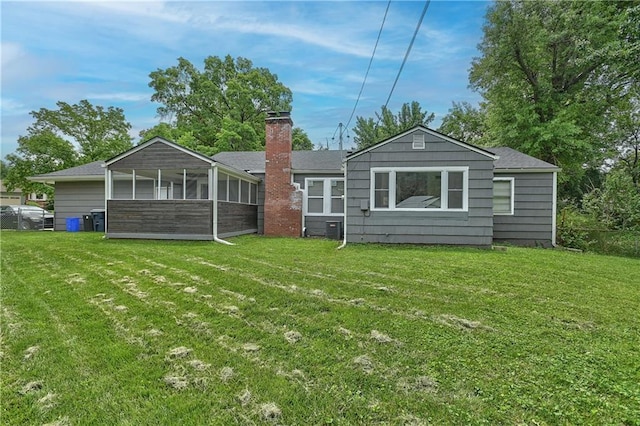 7824 Terrace St, Kansas City, MO 64114 - rear view of house featuring a sunroom, a lawn, and a chimney