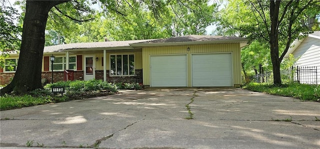 1113 W 27th St, Lawrence, KS 66046 - ranch-style house with a garage, concrete driveway, brick siding, and covered porch