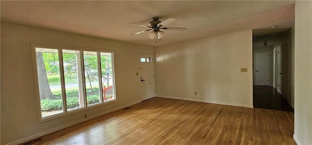 1113 W 27th St, Lawrence, KS 66046 - unfurnished room featuring wood finished floors, ceiling fan, and a textured ceiling