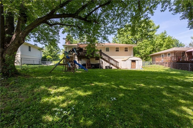 2905 Ajax Rd, Saint Joseph, MO 64503 - fenced backyard with stairway, a storage shed, a playground, and a deck
