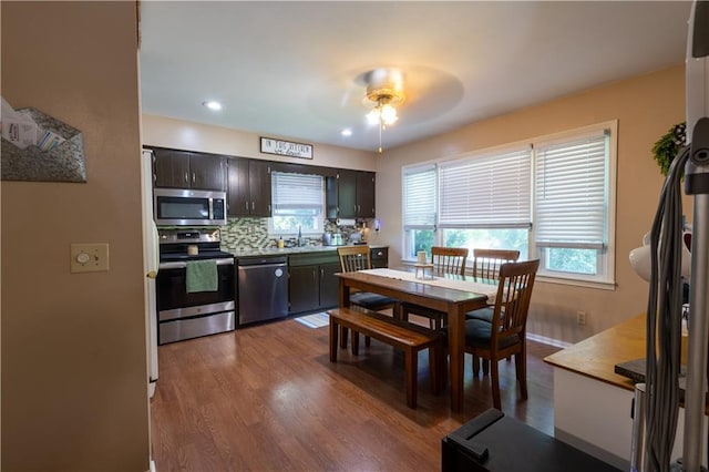 2905 Ajax Rd, Saint Joseph, MO 64503 - kitchen featuring appliances with stainless steel finishes, dark wood-style floors, ceiling fan, decorative backsplash, and plenty of natural light