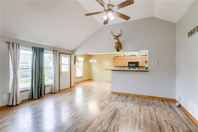 506 12th Ter, Tonganoxie, KS 66086 - unfurnished living room with ceiling fan, light wood-style flooring, and high vaulted ceiling