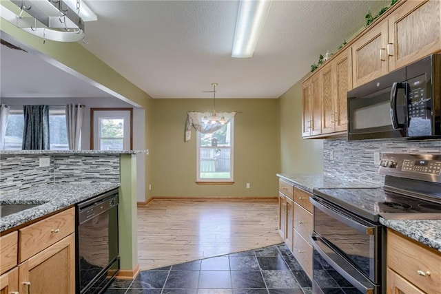 506 12th Ter, Tonganoxie, KS 66086 - kitchen featuring black appliances, backsplash, healthy amount of natural light, and a textured ceiling