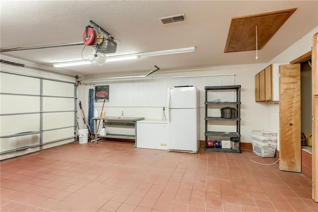 506 12th Ter, Tonganoxie, KS 66086 - garage with freestanding refrigerator and a garage door opener