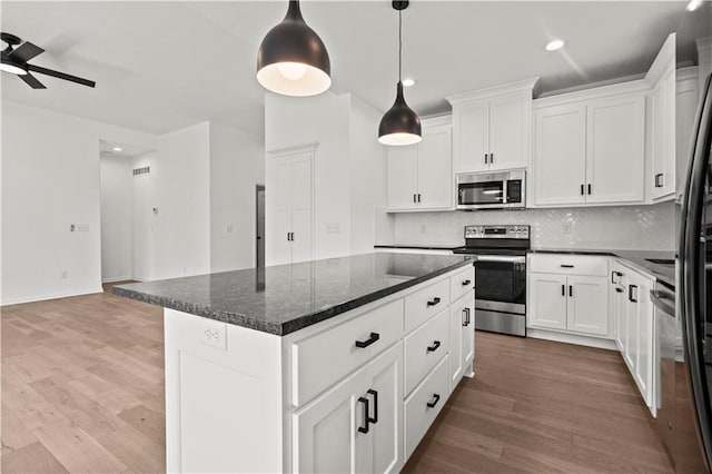 20015 W 221st St, Spring Hill, KS 66083 - kitchen featuring stainless steel appliances, a center island, backsplash, a ceiling fan, and light wood-style floors