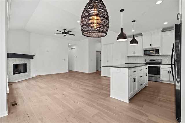 20015 W 221st St, Spring Hill, KS 66083 - kitchen with appliances with stainless steel finishes, a ceiling fan, open floor plan, dark countertops, and lofted ceiling