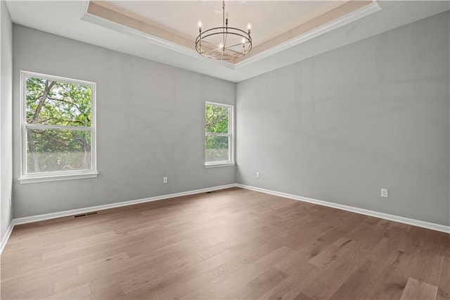 20015 W 221st St, Spring Hill, KS 66083 - spare room with a raised ceiling, healthy amount of natural light, a chandelier, wood finished floors, and ornamental molding