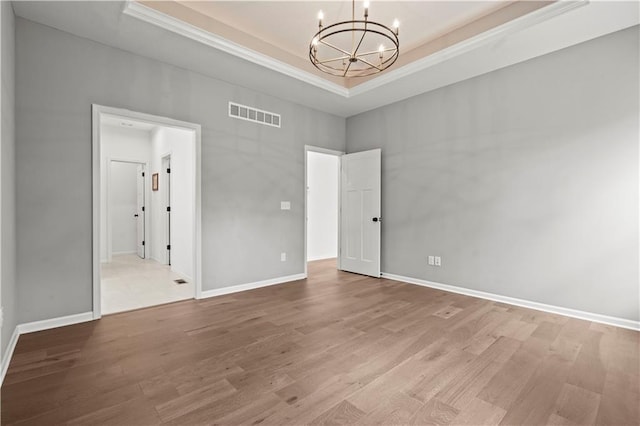 20015 W 221st St, Spring Hill, KS 66083 - unfurnished room with a tray ceiling, a chandelier, ornamental molding, and wood finished floors