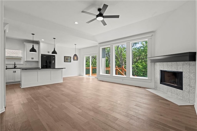 20015 W 221st St, Spring Hill, KS 66083 - unfurnished living room featuring light wood finished floors, recessed lighting, a tiled fireplace, and a ceiling fan
