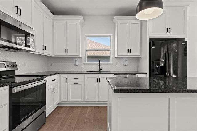 20015 W 221st St, Spring Hill, KS 66083 - kitchen with appliances with stainless steel finishes, light wood-type flooring, white cabinetry, and tasteful backsplash