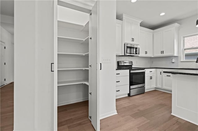 20015 W 221st St, Spring Hill, KS 66083 - kitchen with stainless steel appliances, light wood finished floors, white cabinetry, backsplash, and recessed lighting