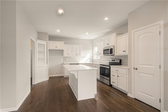6110 NE 118th St, Kansas City, MO 64156 - kitchen with appliances with stainless steel finishes, white cabinets, decorative backsplash, a center island, and dark wood-style flooring