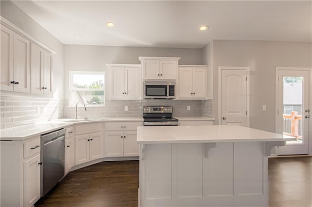 6110 NE 118th St, Kansas City, MO 64156 - kitchen featuring stainless steel appliances, white cabinets, a center island, dark wood finished floors, and light countertops