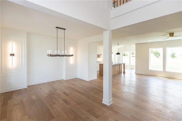 18505 Mohawk Ln, Overland Park, KS 66085 - unfurnished living room with light wood-type flooring and a chandelier
