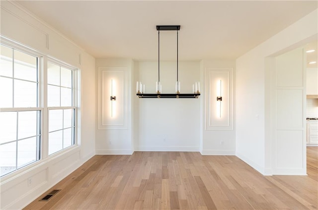 18505 Mohawk Ln, Overland Park, KS 66085 - unfurnished dining area featuring light wood-style floors and baseboards