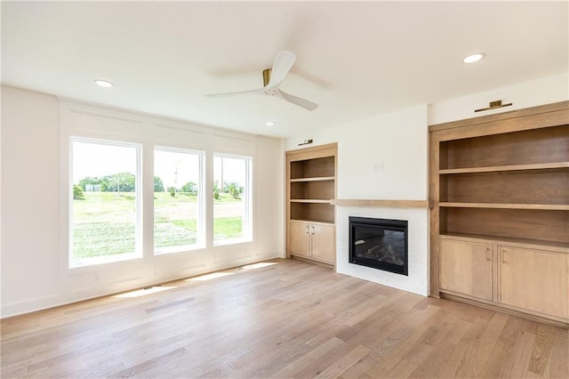 18505 Mohawk Ln, Overland Park, KS 66085 - unfurnished living room with a glass covered fireplace, light wood-style floors, a ceiling fan, built in features, and recessed lighting