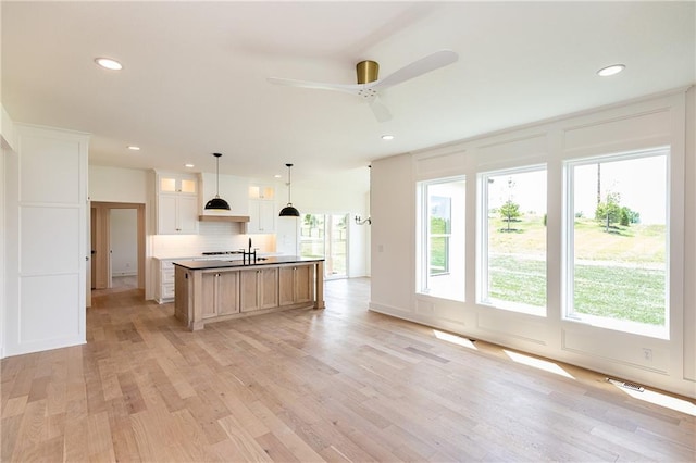 18505 Mohawk Ln, Overland Park, KS 66085 - kitchen featuring recessed lighting, tasteful backsplash, light wood-style floors, a ceiling fan, and glass insert cabinets