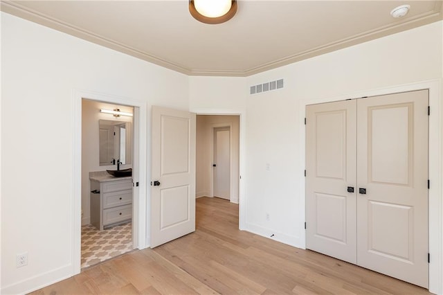 18505 Mohawk Ln, Overland Park, KS 66085 - unfurnished bedroom with light wood finished floors, a closet, connected bathroom, and crown molding
