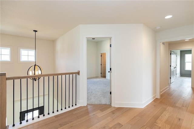 18505 Mohawk Ln, Overland Park, KS 66085 - hall featuring light wood finished floors, a chandelier, recessed lighting, and an upstairs landing