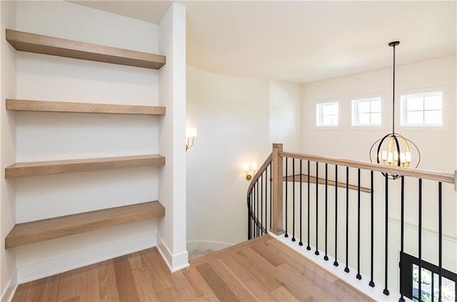 18505 Mohawk Ln, Overland Park, KS 66085 - stairs featuring a chandelier and wood finished floors