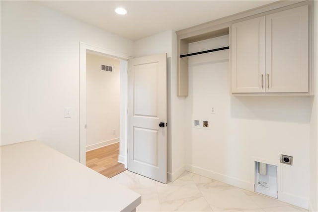 18505 Mohawk Ln, Overland Park, KS 66085 - laundry area featuring hookup for an electric dryer, cabinet space, recessed lighting, light marble finish flooring, and hookup for a washing machine