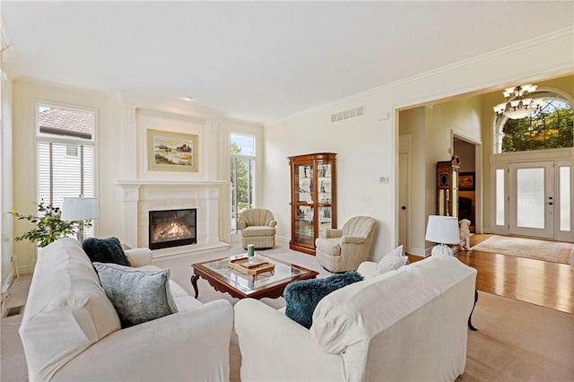 5716 W 146th St, Overland Park, KS 66223 - carpeted living area featuring crown molding, a glass covered fireplace, and a chandelier