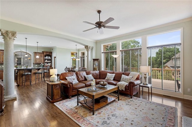 5716 W 146th St, Overland Park, KS 66223 - living area featuring arched walkways, a ceiling fan, ornamental molding, dark wood-style flooring, and ornate columns