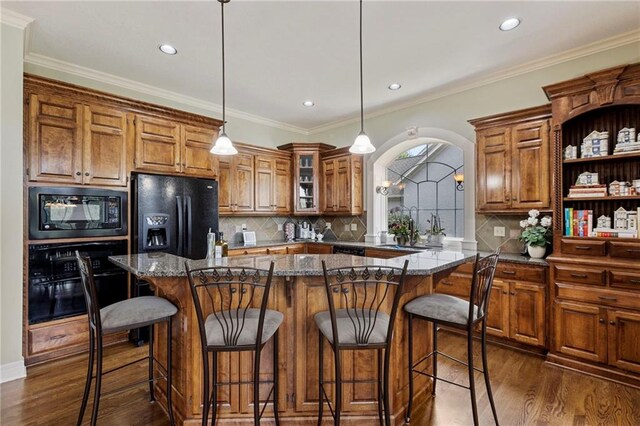 5716 W 146th St, Overland Park, KS 66223 - kitchen featuring black appliances, brown cabinets, dark wood-style floors, tasteful backsplash, and recessed lighting
