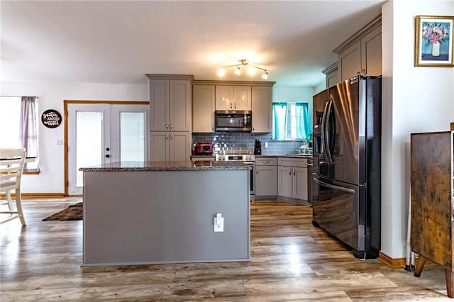 198 SE 455th Rd, Warrensburg, MO 64093 - kitchen with stainless steel appliances, gray cabinetry, a kitchen island, backsplash, and light wood-type flooring