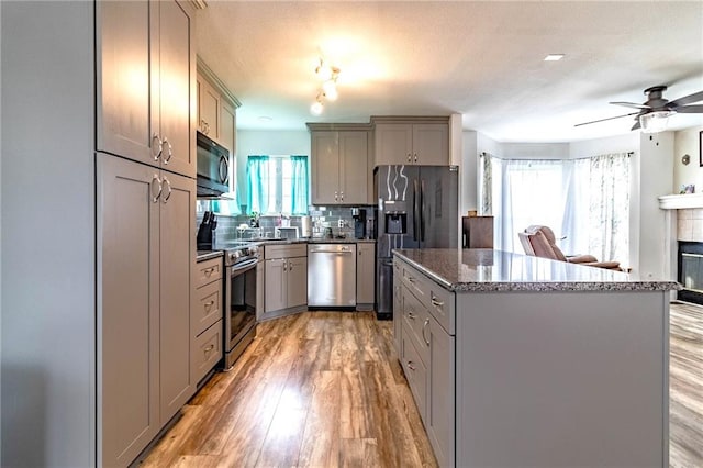 198 SE 455th Rd, Warrensburg, MO 64093 - kitchen featuring stainless steel appliances, gray cabinets, a kitchen island, light wood-type flooring, and a ceiling fan