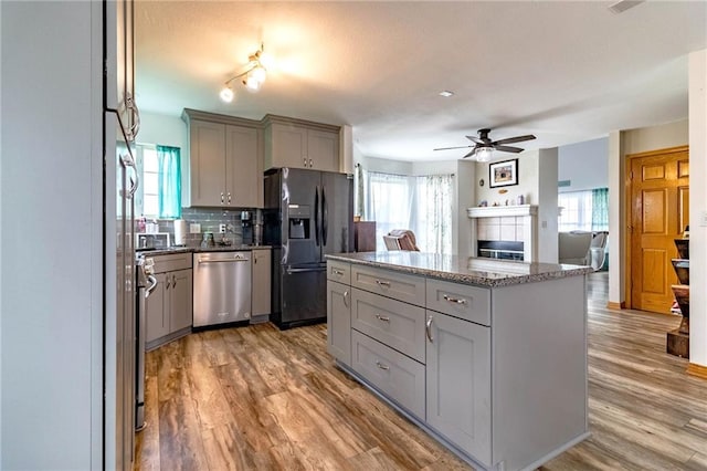 198 SE 455th Rd, Warrensburg, MO 64093 - kitchen with appliances with stainless steel finishes, gray cabinetry, a ceiling fan, and light wood finished floors