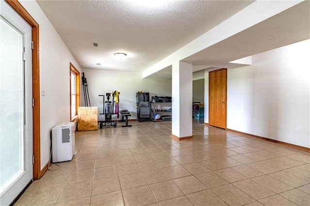 198 SE 455th Rd, Warrensburg, MO 64093 - exercise area featuring light tile patterned floors, a textured ceiling, and plenty of natural light
