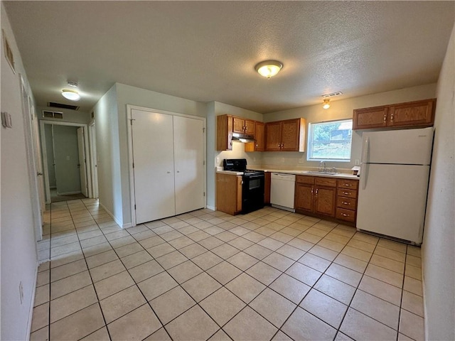 2804 Wenzel Ave, Kansas City, MO 64128 - kitchen featuring white appliances, under cabinet range hood, light countertops, light tile patterned floors, and brown cabinetry