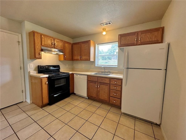 2804 Wenzel Ave, Kansas City, MO 64128 - kitchen featuring white appliances, under cabinet range hood, light countertops, brown cabinetry, and light tile patterned flooring