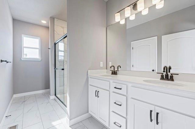 12508 S Parkwood Ln, Lees Summit, MO 64086 - full bath with marble look tile flooring, double vanity, a shower stall, and recessed lighting