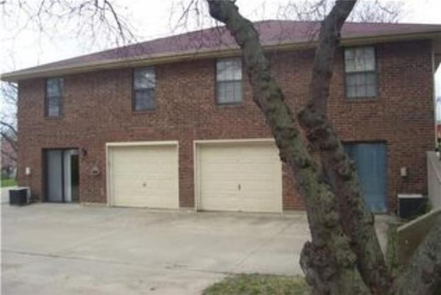 1019 N Kiger Rd, Independence, MO 64050 - colonial house with driveway, a garage, and brick siding