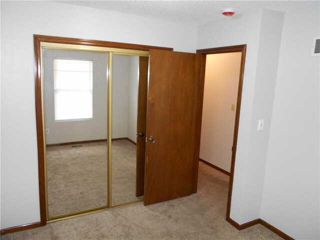 1019 N Kiger Rd, Independence, MO 64050 - unfurnished bedroom featuring carpet flooring, a closet, and a textured ceiling