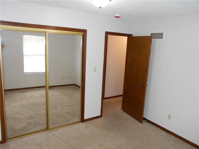 1019 N Kiger Rd, Independence, MO 64050 - unfurnished bedroom featuring light carpet, a closet, and a textured ceiling