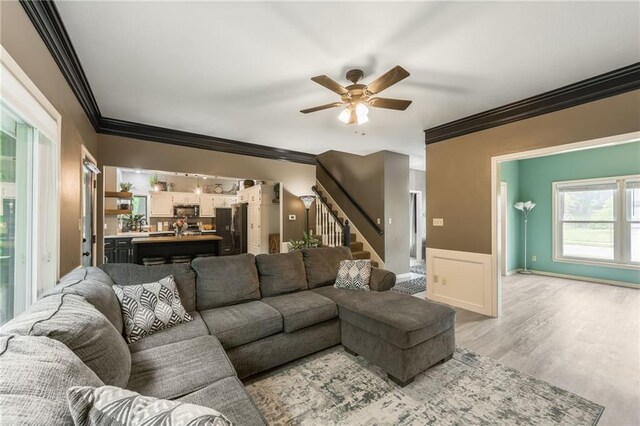 617 Butternut Ln, Liberty, MO 64068 - living room with crown molding, stairs, a ceiling fan, and light wood-type flooring