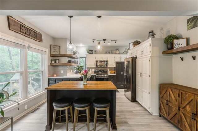 617 Butternut Ln, Liberty, MO 64068 - kitchen with stainless steel appliances, open shelves, butcher block countertops, a kitchen island, and white cabinets