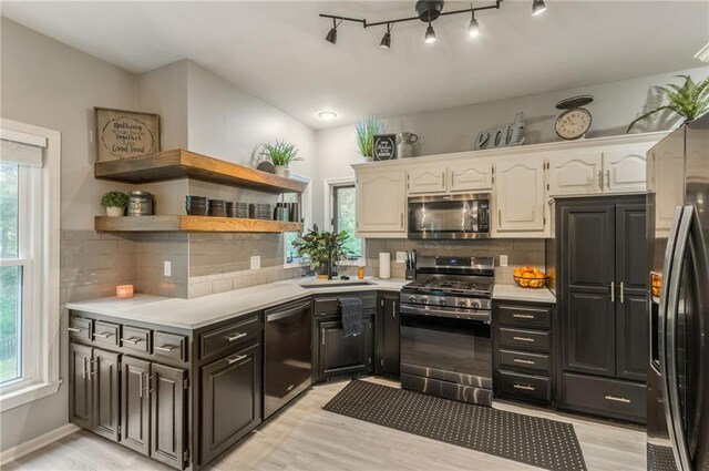 617 Butternut Ln, Liberty, MO 64068 - kitchen with appliances with stainless steel finishes, light countertops, white cabinets, and light wood-style flooring