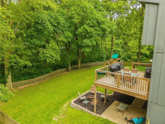 617 Butternut Ln, Liberty, MO 64068 - fenced backyard featuring a wooden deck, a playground, and view of scattered trees