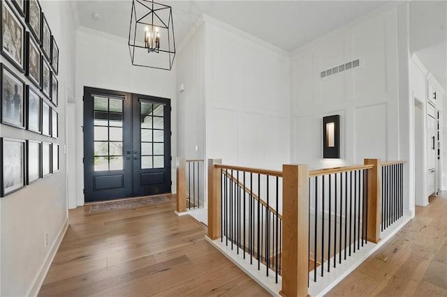 17316 Noland St, Overland Park, KS 66221 - entryway with a high ceiling, hardwood / wood-style floors, a chandelier, french doors, and crown molding