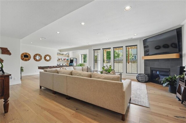 17316 Noland St, Overland Park, KS 66221 - living room featuring recessed lighting, light wood-style floors, and a glass covered fireplace
