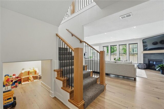 17316 Noland St, Overland Park, KS 66221 - stairs featuring wood-type flooring, a tile fireplace, and recessed lighting
